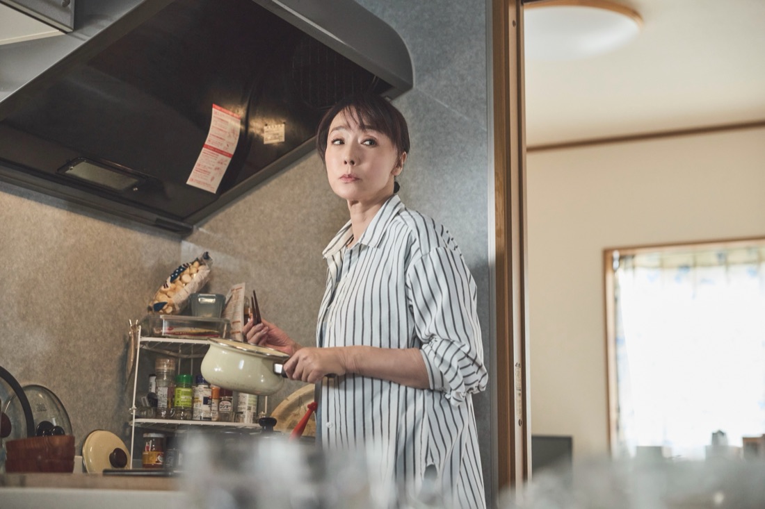 場面写真：台所で鍋を手にしたまま振り返る陽子。